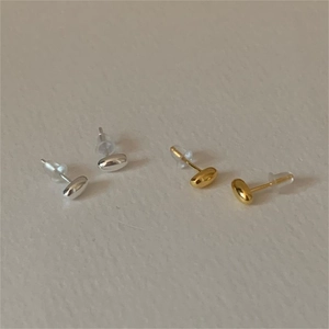 Polished silver and gold bean-shaped minimalist stud earrings with silicone backs