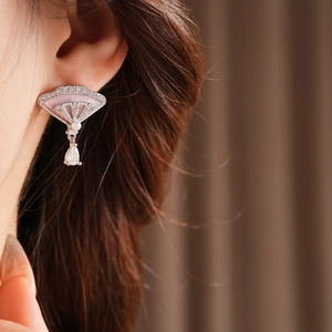 Detail of fan-shaped drop earring with pink inlay and sparkling cubic zirconia stones