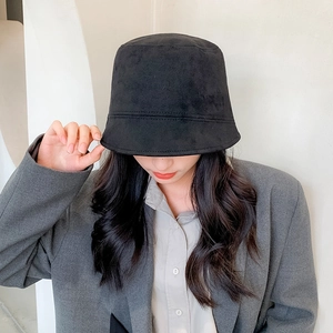 Sombrero bucket de ante negro unisex combinado con una elegante chaqueta de traje gris