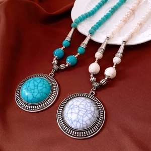 Detail of vintage bohemian necklaces with turquoise beads and engraved round pendants