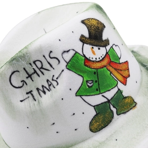 Détail macro d'une broderie bonhomme de neige et texte de Noël sur chapeau en feutre