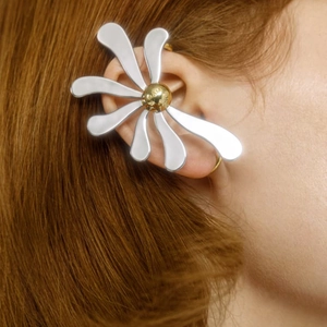 Macro shot of two-tone flower ear cuff with gold center bead and polished silver petals