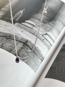 Artistic detail of S925 silver necklace featuring a purple teardrop crystal pendant