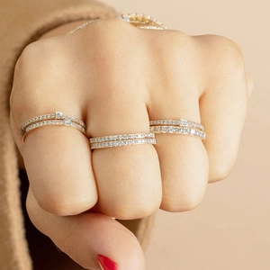 Close-up of stacked gold cocktail rings with micro-pave zircons on a hand