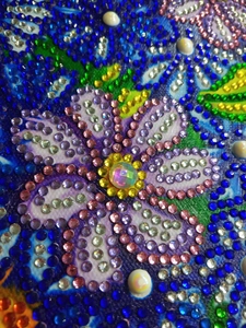 Macro shot of colorful resin diamonds on a DIY handbag showing 3D floral pattern details