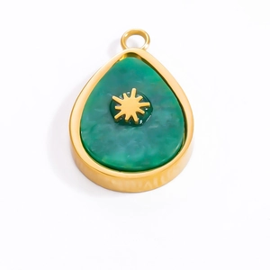 Detail showing a golden teardrop pendant with green natural stone and star motif