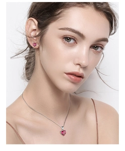 Elegant set with red heart-shaped gemstone necklace and matching stud earrings on model