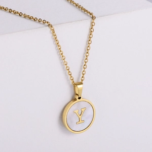 Detalle macro del colgante de oro 18k con letra Y sobre incrustación de nácar