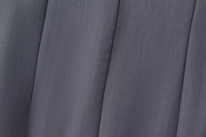 Primer plano de la tela de sarga gris carbón con la textura plisada detallada del vestido