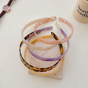 Collection of acetate wide headbands in leopard print and solid colors on a stone base