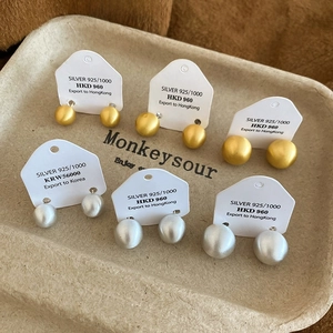 Detailed view of matte gold and silver ball stud earrings in 925 silver finish