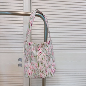 Detail of floral embroidery on pink heart-shaped tote bag with cotton-linen texture
