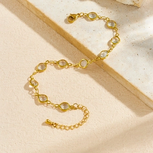Minimalist gold-plated stainless steel bracelet with crystal stones on marble base