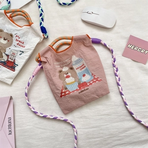 Détail de broderie d'ours sur mini sac en tissu oxford avec bandoulière tressée colorée