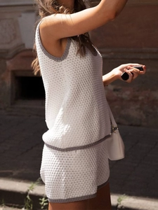 Detail of white knit two-piece set with grey contrast piping and hollow crochet texture