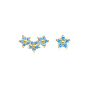 Dettaglio di orecchini a fiore in oro con pietre blu cielo e design asimmetrico moderno