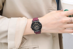 Détail d'une montre femme en cuir violet avec cadran serti de diamants et index dorés