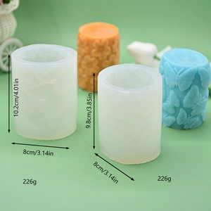 3D butterfly and floral cylinder silicone candle molds with finished embossed wax pillars
