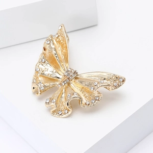 Macro shot of gold enamel butterfly brooch with sparkling crystals on white background