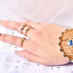 Bague dorée aux cristaux rectangulaires colorés et bracelet ajouré à pierre bleue précieuse