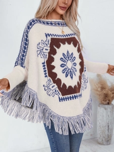 Vintage bohemian beige knit poncho with floral patterns and blue fringe trim on model