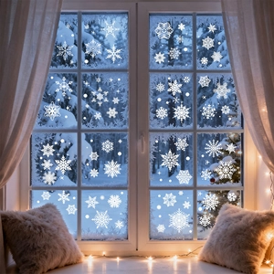 Close-up of white snowflake window clings on glass with warm indoor holiday lighting