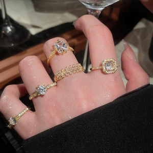Close-up of gold geometric heart ring set with sparkling cubic zirconia on fingers