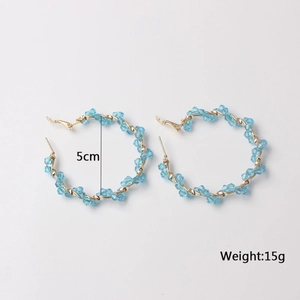 Detail view of 5cm gold hoop earrings with light blue crystals and size measurement labels