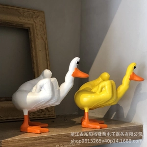 Detailed view of two funny cartoon duck statues with a humorous middle finger pose