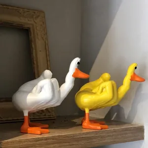 Detailed view of two funny cartoon duck statues with a humorous middle finger pose
