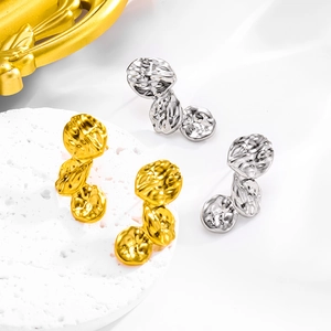 Detailed macro view of layered hammered petal earrings in gold and silver finish