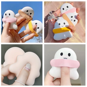 Macro detail of white ghost shaped cosmetic puffs with pink and yellow ribbons