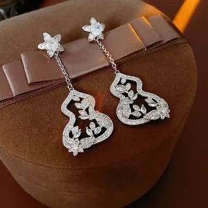 Elegant silver tassel earrings with flower and gourd charms set in fine cubic zirconia