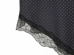 Gros plan détaillé du tissu noir à pois avec bordure en dentelle noire délicate