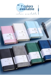Detailed shot of seven assorted A7 hardcover notebooks with elastic bands and pens