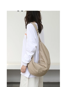 Borsa a tracolla in nylon kaki indossata che mostra la grande capacità e l'effetto drappeggiato