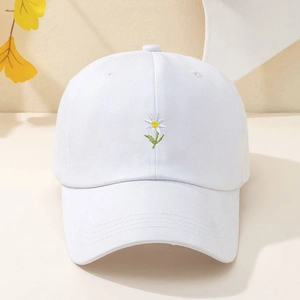 Close-up of small daisy embroidery on a white cotton baseball cap for summer sun protection