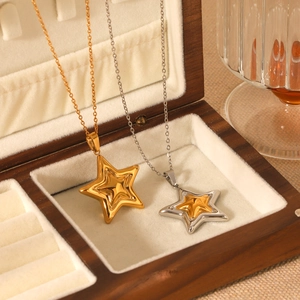 Macro shot of two-tone gold and silver star necklaces in a premium jewelry box