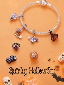 Detail of S925 silver Halloween charms with purple crystals and pumpkin cat on orange backdrop