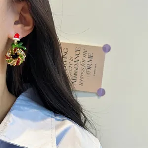 Detailed view of handmade beaded Christmas wreath earrings with red bow and festive charms