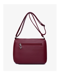 Detail of burgundy pebbled leather handbag featuring a rear zipper pocket and strap