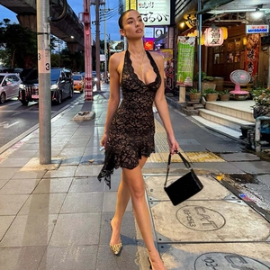 Détail d'une robe noire en dentelle dos nu avec licou et ourlet irrégulier sexy