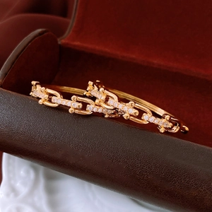 Macro shot of 18K gold plated link bracelet with sparkling inlaid zircons on luxury case