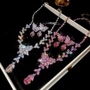 Macro detail of zircon butterfly tassel necklace and earrings jewelry set in display box