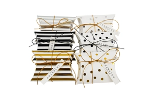 Close-up of elegant pillow gift boxes with gold stripes and dots for wedding favors
