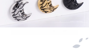 Macro view of crescent moon pendants featuring embossed skull and flame punk patterns
