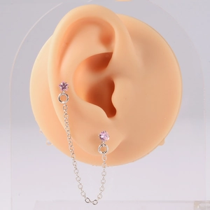 Detail of silver ear bone chain featuring pink star-shaped zirconia and fine links
