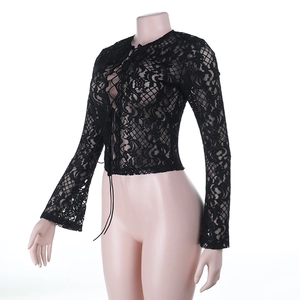 Détail d'un crop top en dentelle noire transparente avec lacets frontaux et fleurs