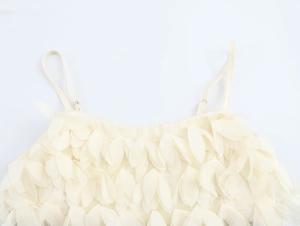 Detail of cream crop top featuring dense 3D feather leaf textures and adjustable straps