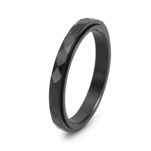 Detail shot of a black stainless steel spinner ring with diamond-cut geometric facets